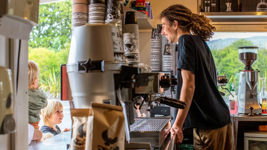 Barista smiling at children inside Raglan Roast café
