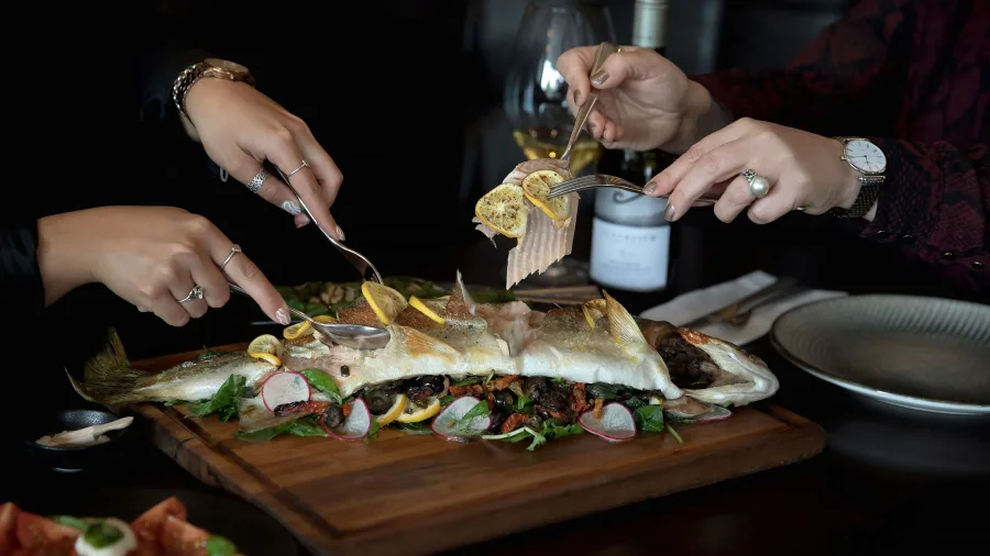 Freshly prepared trout dish with lemon and greens at Vine Eatery & Bar in Lake Taupō.