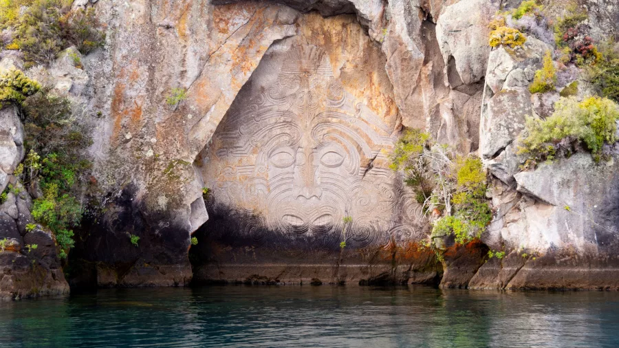 Close-up view of the intricate Māori rock carvings at Mine Bay, Lake Taupō