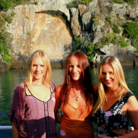 Group of friends smiling in front of the Ngātoroirangi Māori Rock Carvings