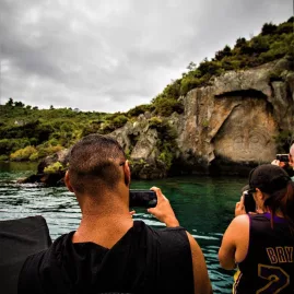 Cruise guests taking photos of the Ngātoroirangi carvings on Lake Taupō