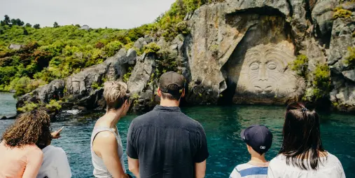 Family admiring the Māori Rock Carvings from a scenic boat cruise on Lake Taupō