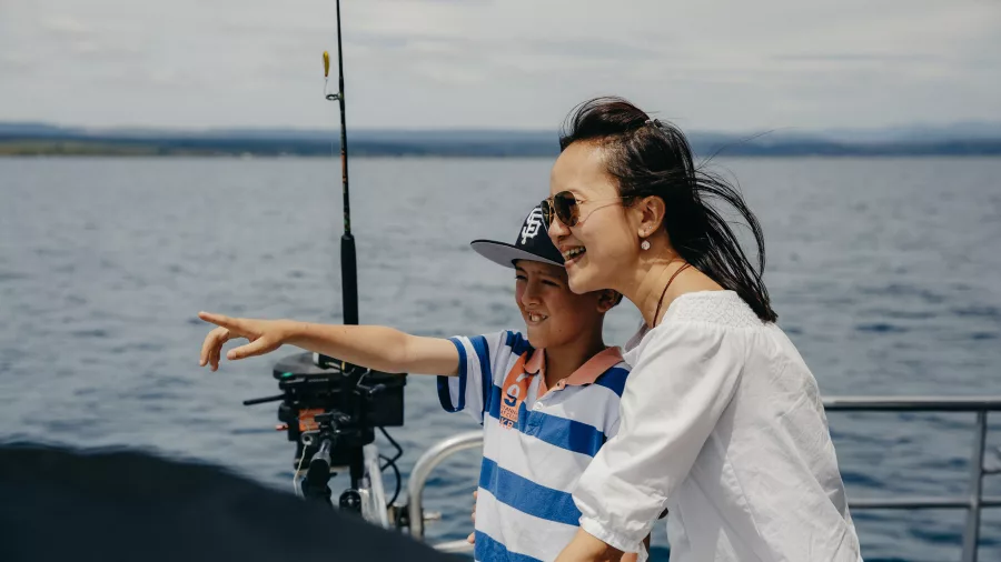 Mother and son smiling and pointing during Lake Taupō cruise