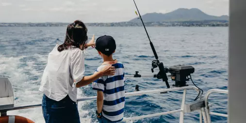 Mother and son fishing from the back of a charter boat on Lake Taupō