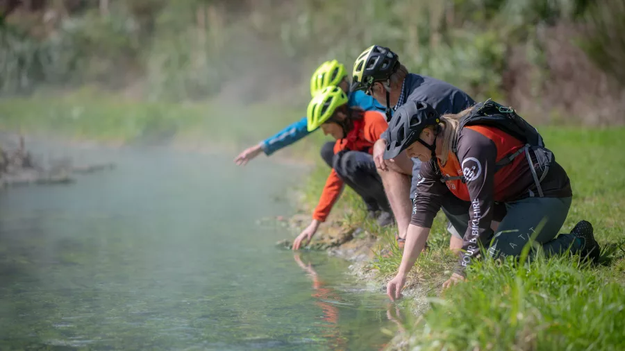 Riders testing the temperature of a geothermal stream near Wairakei