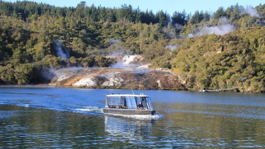 Boat cruise approaching Orakei Korako’s steaming cliffs and geothermal pools