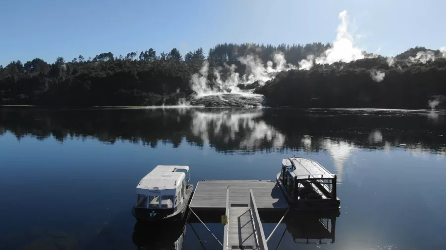 Steam rising from the geothermal terraces at Orakei Korako reflected on the calm surface of Lake Ohakuri