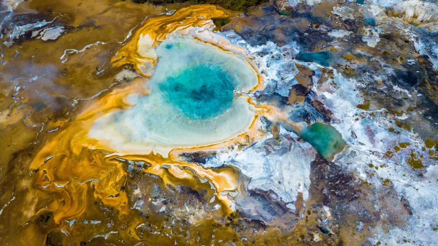 Vibrant blue geothermal spring with orange silica terraces at Orakei Korako