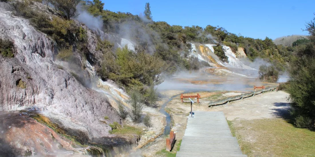 Wooden walkway through geothermal steam vents and colourful terraces at Orakei Korako