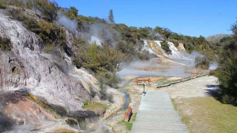 Wooden walkway through geothermal steam vents and colourful terraces at Orakei Korako