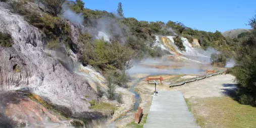 Wooden walkway through geothermal steam vents and colourful terraces at Orakei Korako