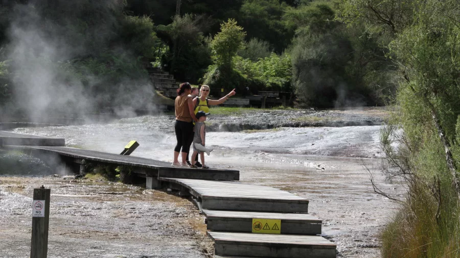 Visitors pausing along the geothermal boardwalk at Orakei Korako