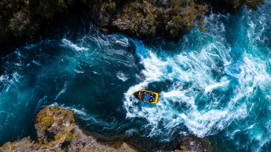 Drone shot of a Rapids Jet boat powering through swirling rapids on the Waikato River near Taupō.