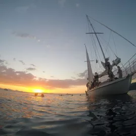 Group preparing to swim from Sail Barbary into Lake Taupō at sunset