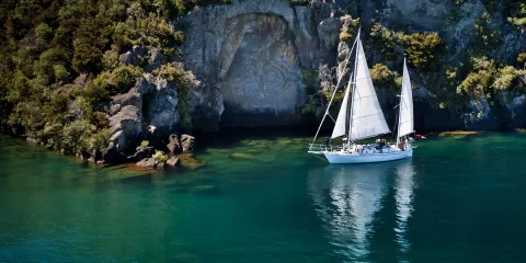 Sail Barbary anchored at Mine Bay in front of the Māori Rock Carvings on Lake Taupō