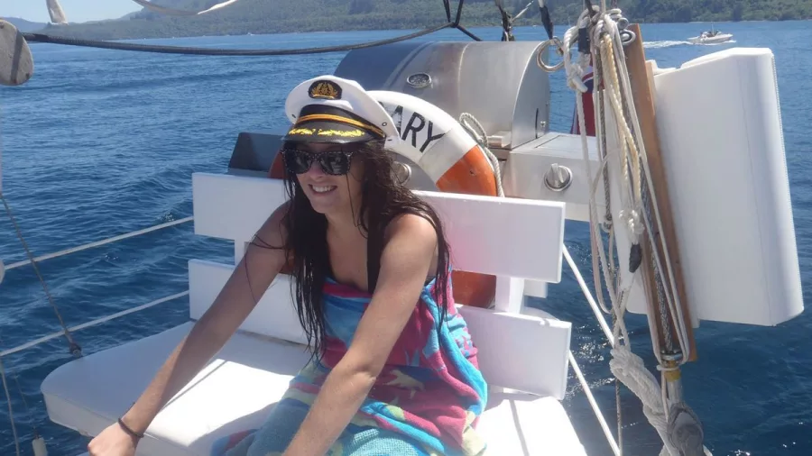Young woman smiling while wearing a captain’s hat on Sail Barbary on Lake Taupō