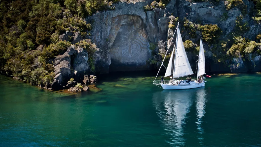 Sail Barbary anchored at Mine Bay in front of the Māori Rock Carvings on Lake Taupō