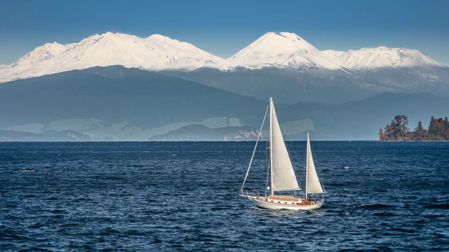Sailing boat on Lake Taupō with snow-capped Mount Ruapehu in the background