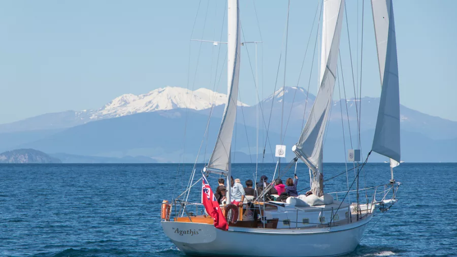 Rear view of Sail Barbary boat with Mount Tongariro and Ruapehu in the distance