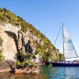 Sailboat floating beside the Māori rock carvings at Lake Taupō