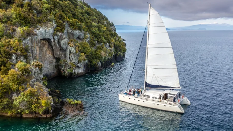 Tiua sailing near Mine Bay Māori Rock Carvings on Lake Taupō during an afternoon cruise