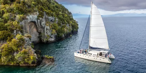 Tiua sailing near Mine Bay Māori Rock Carvings on Lake Taupō during an afternoon cruise