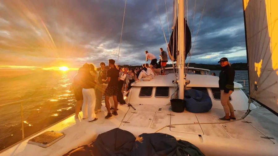 Guests enjoying a vibrant sunset aboard Tiua on Lake Taupō