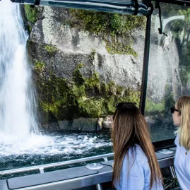 Two women viewing Otupoto Falls from the Venture Beyond boat on Lake Taupō