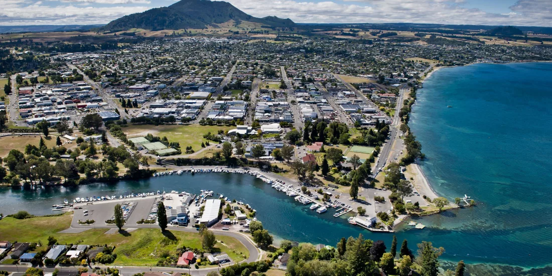 Aerial view of Taupō Boat Harbour, town centre, and Mount Tauhara beside the shores of Lake Taupō in New Zealand.