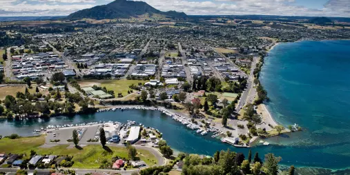 Aerial view of Taupō Boat Harbour, town centre, and Mount Tauhara beside the shores of Lake Taupō in New Zealand.