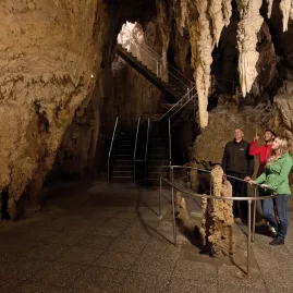 Visitors viewing stalagmites on a guided tour inside Aranui Cave, Waitomo.