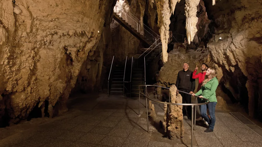 Visitors viewing stalagmites on a guided tour inside Aranui Cave, Waitomo.