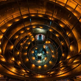 Spiral walkway entrance to Ruakuri Cave in Waitomo illuminated with golden lighting