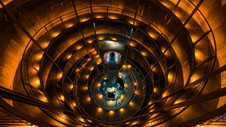 Spiral walkway entrance to Ruakuri Cave in Waitomo illuminated with golden lighting