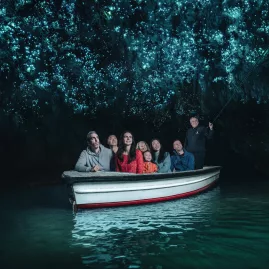 Visitors on a guided boat ride through the glowworm-lit cave at Waitomo, New Zealand