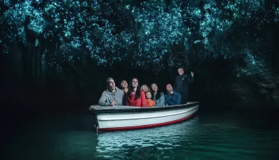 Visitors on a guided boat ride through the glowworm-lit cave at Waitomo, New Zealand