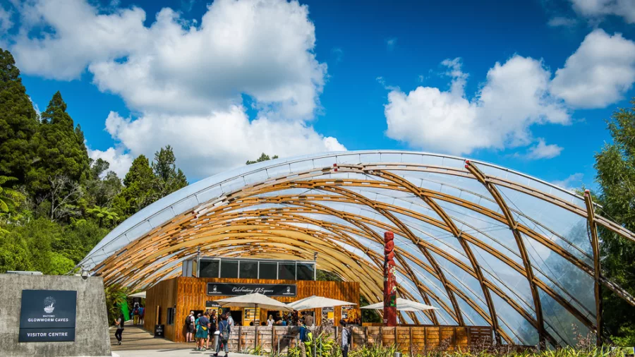 Stunning exterior of the Waitomo Glowworm Caves Visitor Centre with its unique architectural design and lush surroundings in New Zealand.