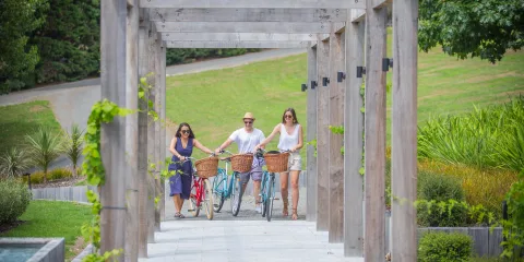 Group walking with bikes through Luna Estate Winery vineyard