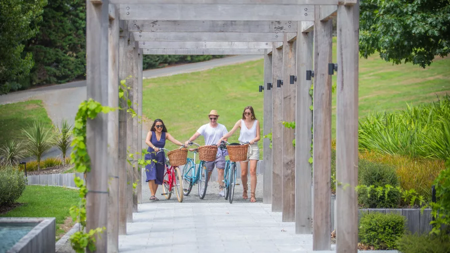 Group walking with bikes through Luna Estate Winery vineyard