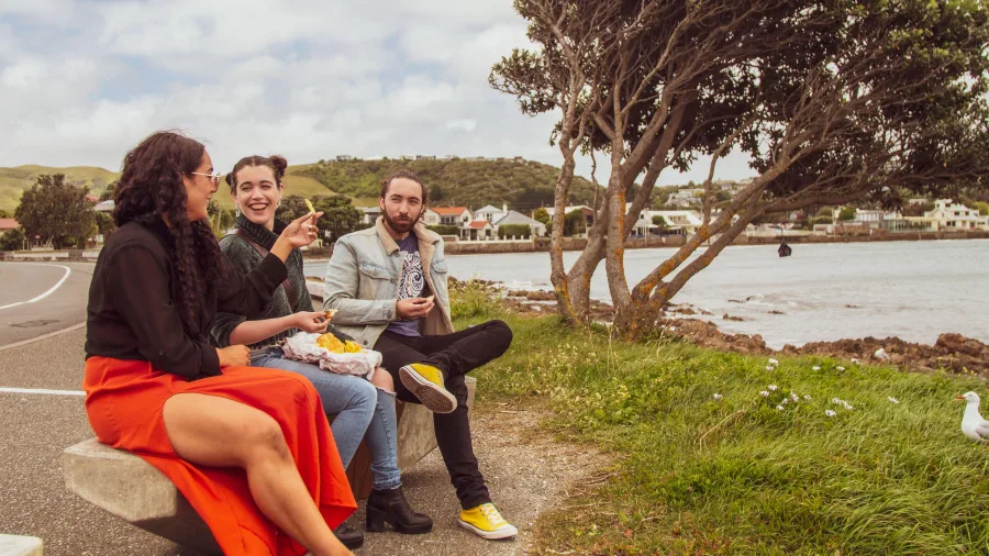 Friends enjoying fish and chips by Plimmerton waterfront