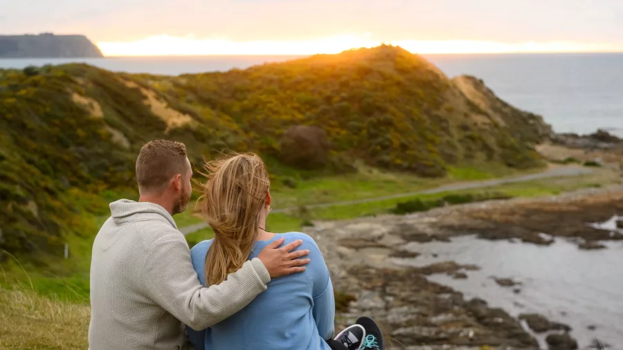 Couple watching the sunset at Whitireia Park in Porirua near Wellington