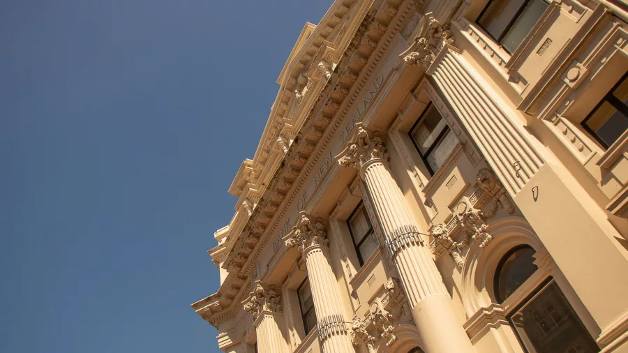Low-angle view of the historic Bank of New Zealand building with ornate pillars in Wellington