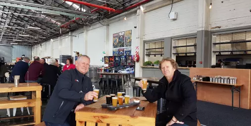 Two men enjoying a craft beer tasting paddle at Boneface Brewery in Upper Hutt