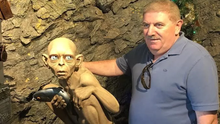 Tourist posing beside a Gollum statue at Weta Cave in Wellington