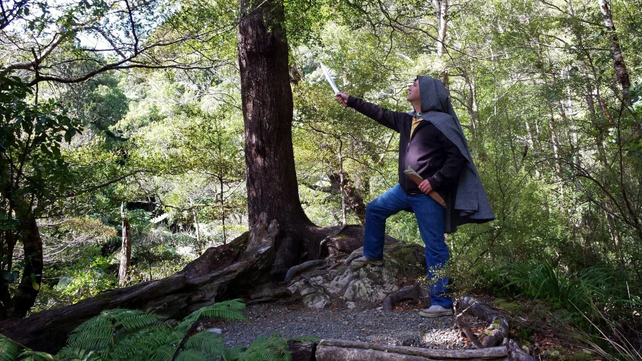John poses with sword in front of the Legolas Tree filming location in Kaitoke Regional Park