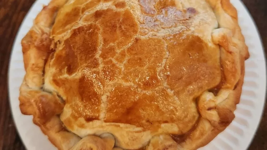Golden-crusted meat pie on a plate from a Wellington food tour stop