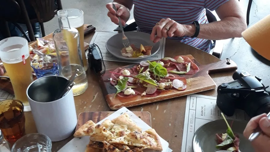Charcuterie board, flatbread, and drinks shared among friends at a Wellington restaurant
