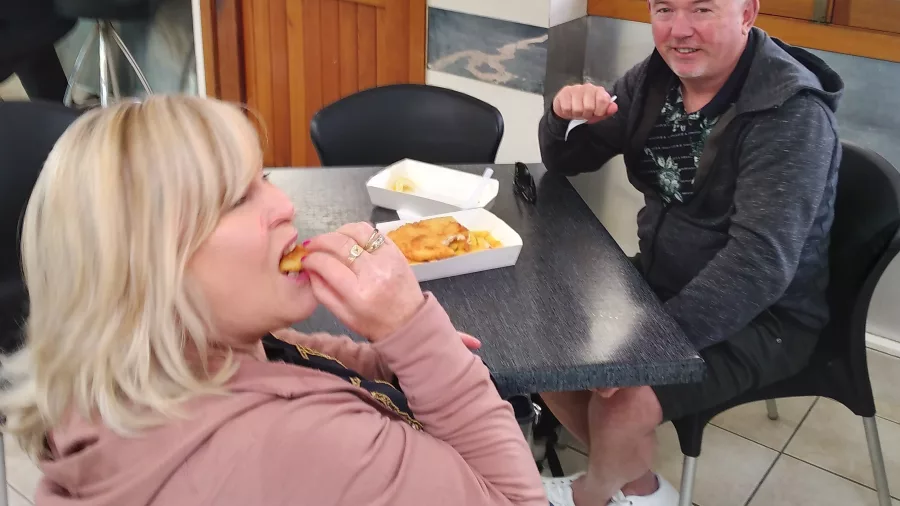 Two people enjoying fish and chips at a casual eatery in Wellington