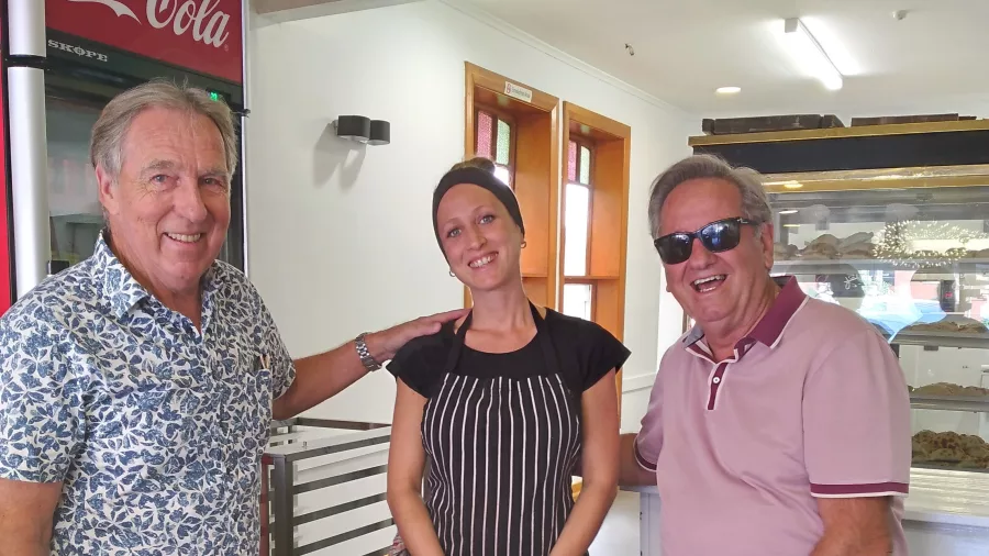 Two guests posing with a local baker during a Wellington food tour