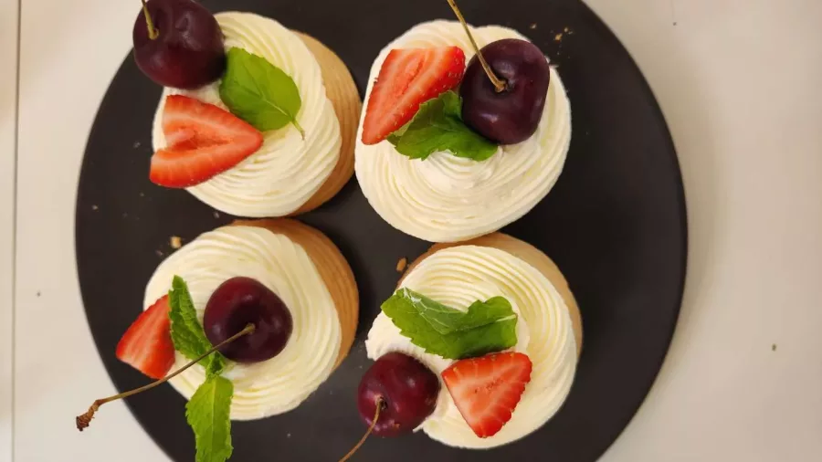 Mini pavlovas topped with cherries, strawberries and mint